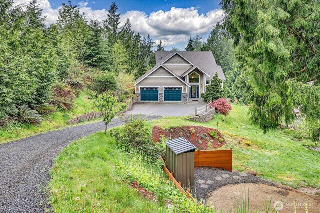 view of front of property with a garage, driveway, and stone siding