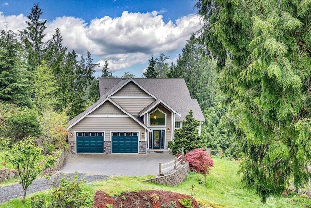craftsman house with a garage, aphalt driveway, and stone siding