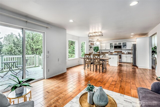 living room featuring baseboards, recessed lighting, and hardwood / wood-style floors