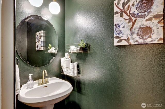 bathroom featuring a sink and a textured wall