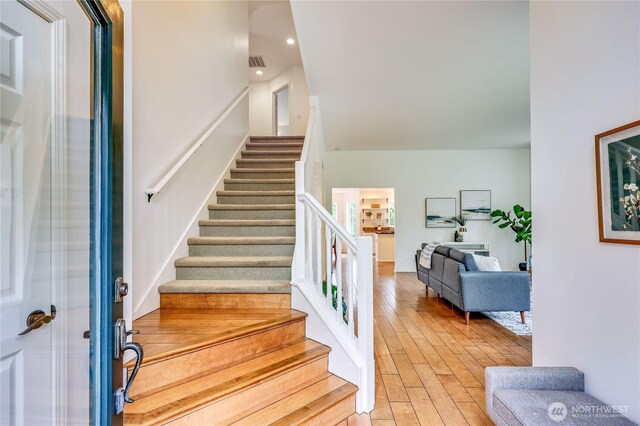 staircase with recessed lighting, visible vents, and wood finished floors