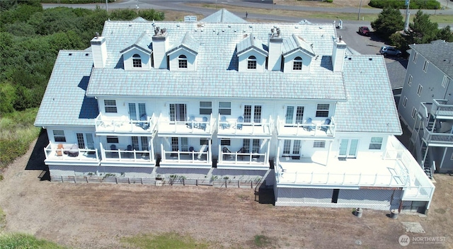 back of property with a chimney and a balcony