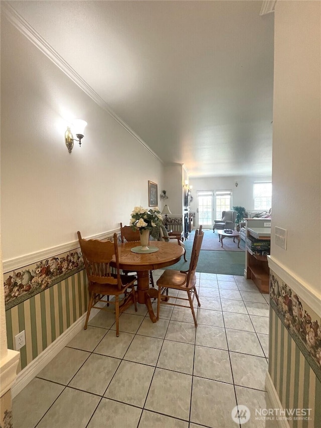 dining room featuring baseboards, ornamental molding, wallpapered walls, and light tile patterned flooring