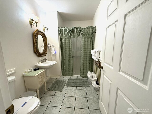 bathroom featuring toilet, tile patterned flooring, and curtained shower