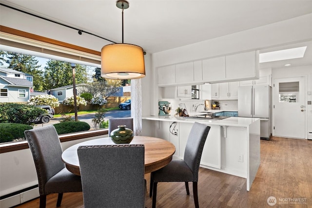 dining room with light wood-style flooring and baseboard heating