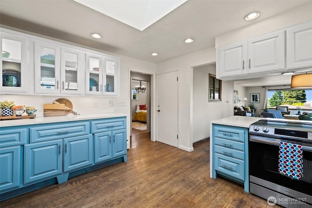 kitchen with stainless steel electric range oven, glass insert cabinets, light countertops, dark wood finished floors, and blue cabinetry