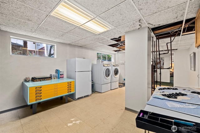 laundry area featuring washing machine and dryer, laundry area, baseboards, and light floors
