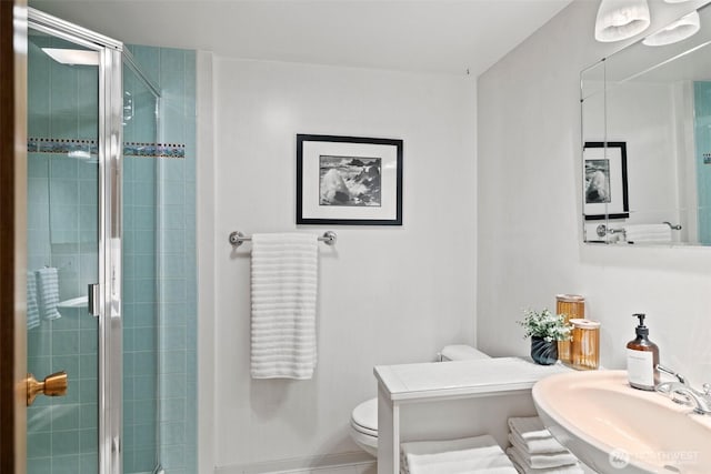 bathroom featuring vanity, toilet, and a stall shower