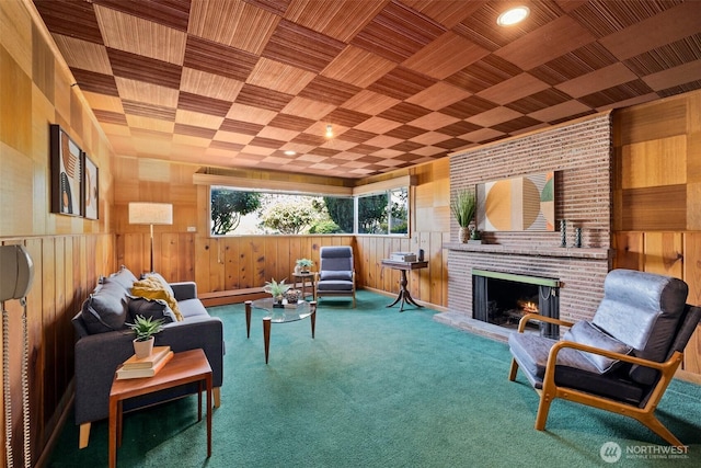 living area featuring wooden walls, a brick fireplace, carpet, and wooden ceiling