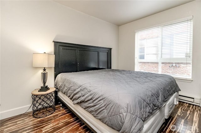 bedroom featuring baseboards, wood finished floors, and a baseboard radiator