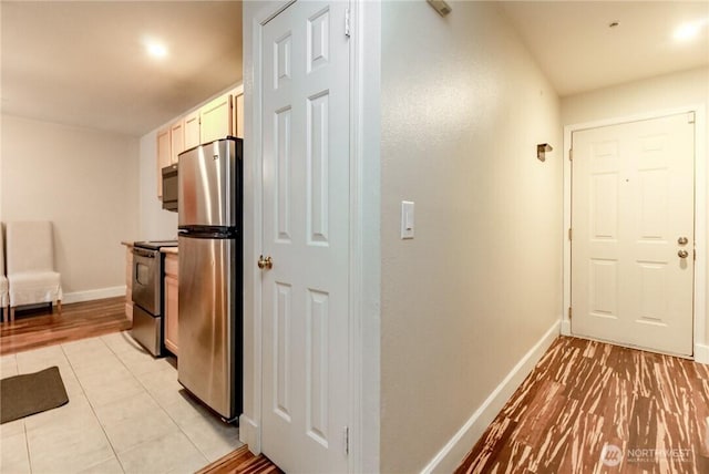 hallway with baseboards and light tile patterned floors