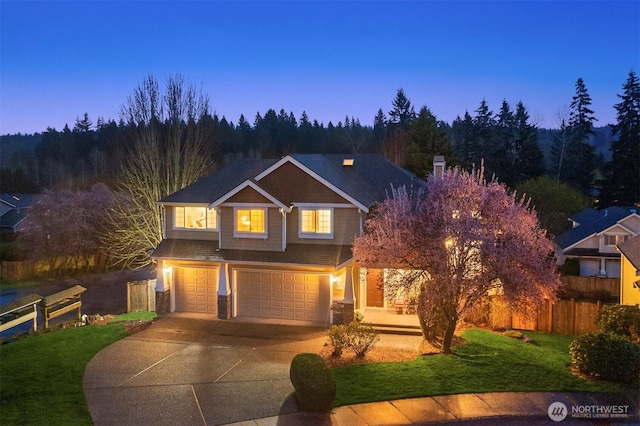 traditional home with fence, driveway, a yard, and a garage