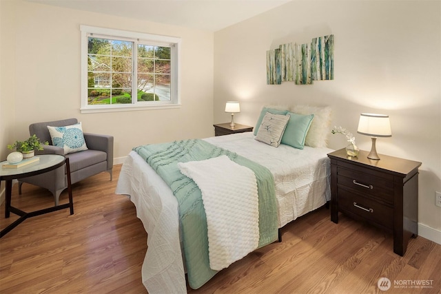 bedroom featuring wood finished floors and baseboards