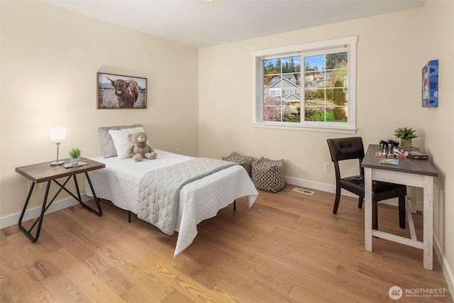 bedroom with light wood-type flooring, visible vents, and baseboards