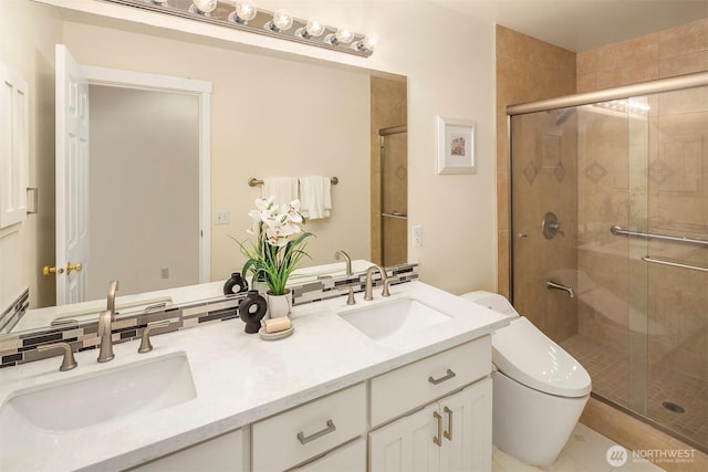 full bathroom featuring toilet, a sink, double vanity, and a stall shower