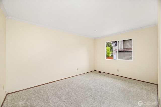 carpeted empty room with crown molding, baseboards, and visible vents