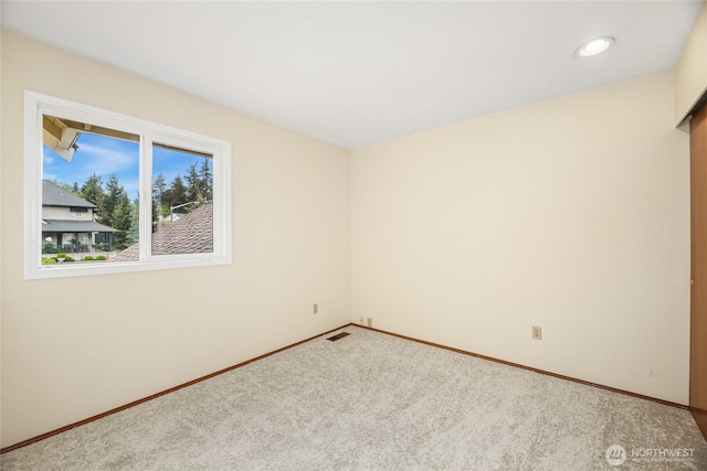 empty room with carpet floors, recessed lighting, baseboards, and visible vents