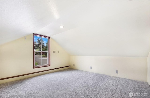 bonus room featuring carpet flooring, a baseboard heating unit, and vaulted ceiling