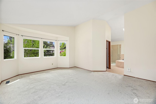 unfurnished room featuring baseboards, carpet flooring, and vaulted ceiling