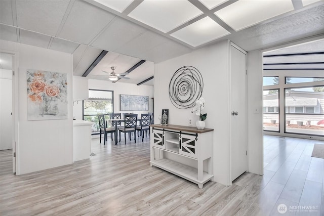 hallway featuring light wood-style floors and beam ceiling