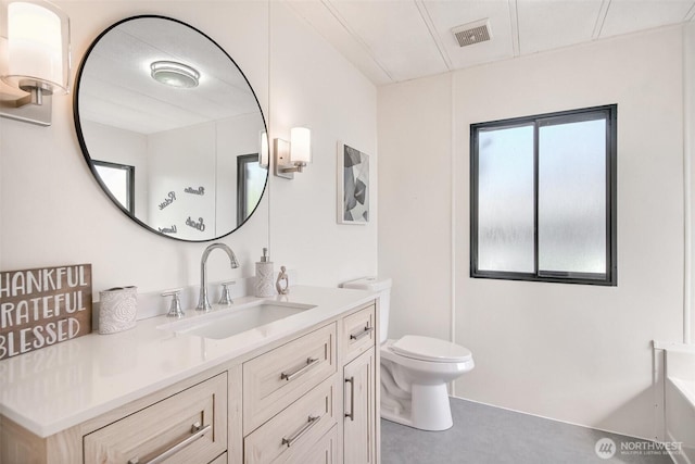 bathroom with visible vents, a tub to relax in, toilet, and vanity