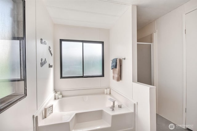 bathroom featuring a bath and a shower stall