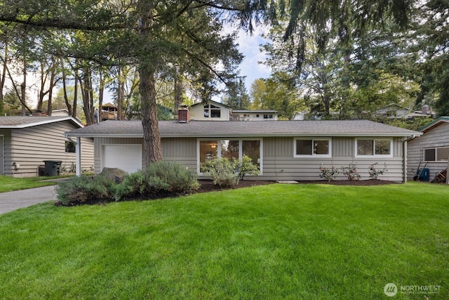view of front facade featuring a chimney, a front lawn, concrete driveway, board and batten siding, and a garage