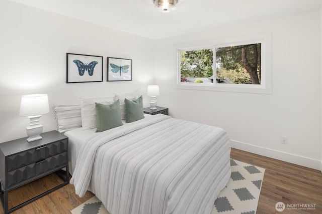 bedroom featuring baseboards and wood finished floors