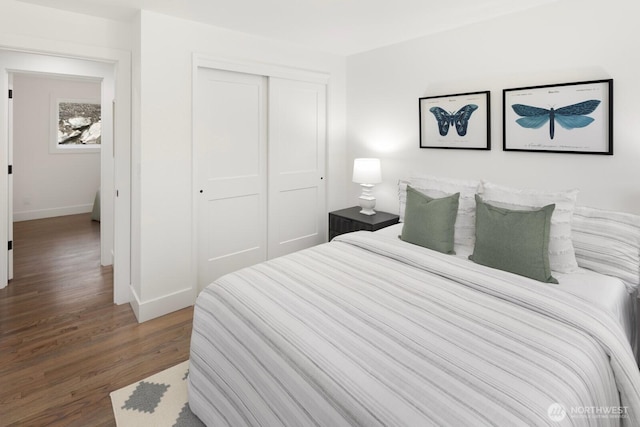 bedroom with baseboards, wood finished floors, and a closet