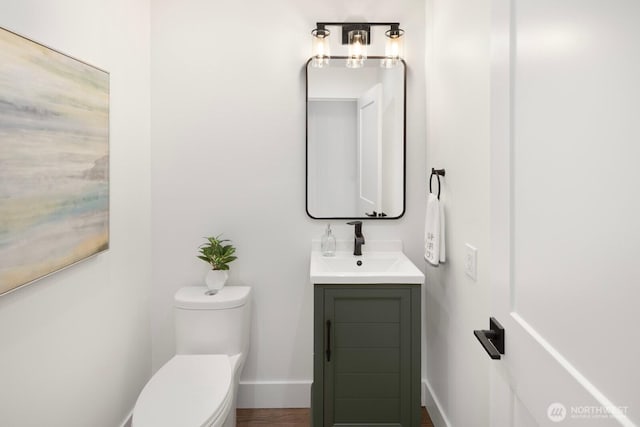 bathroom with vanity, toilet, and baseboards