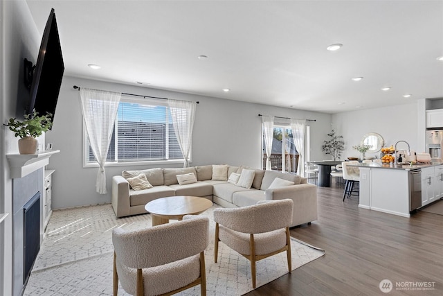 living area featuring a fireplace, light wood finished floors, and recessed lighting