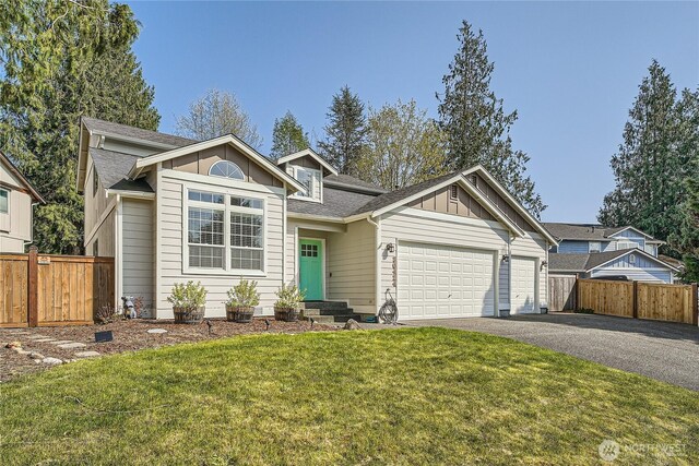 view of front of property featuring board and batten siding, an attached garage, driveway, and fence