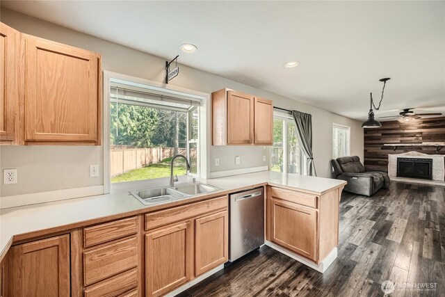 kitchen featuring light countertops, stainless steel dishwasher, a sink, a peninsula, and ceiling fan