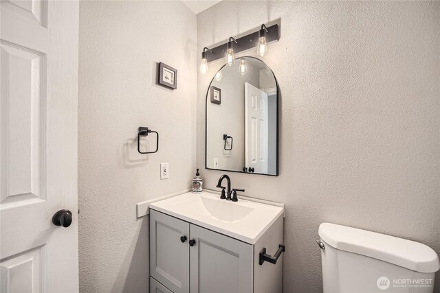 half bathroom featuring toilet and vanity