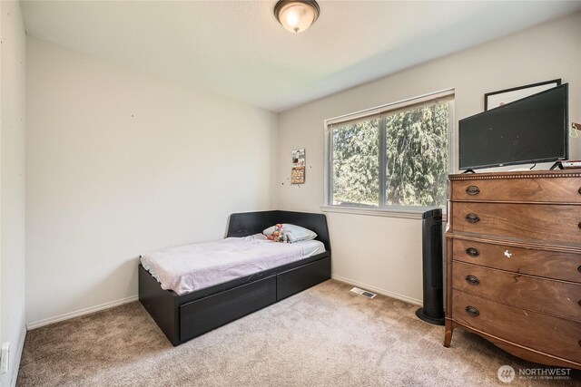 carpeted bedroom featuring baseboards and visible vents