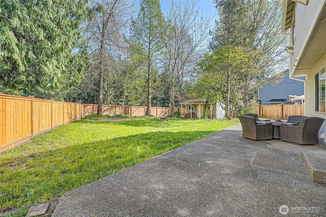 view of yard featuring outdoor lounge area, a fenced backyard, an outbuilding, and a patio