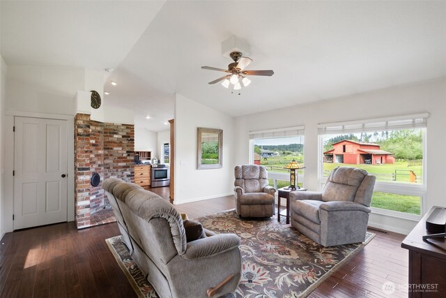 living room featuring lofted ceiling, plenty of natural light, wood-type flooring, a ceiling fan, and baseboards