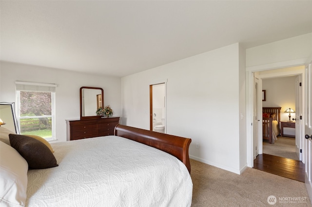 carpeted bedroom featuring baseboards and ensuite bath