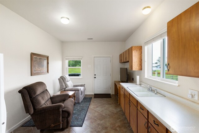 kitchen featuring open floor plan, healthy amount of natural light, light countertops, and brown cabinetry