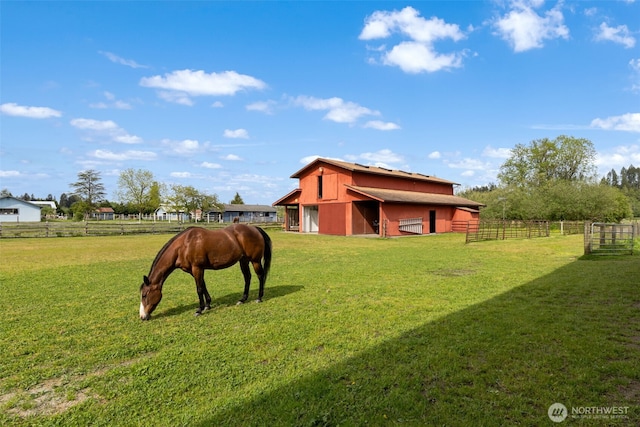view of yard with an exterior structure, an outdoor structure, a view of countryside, and a detached garage