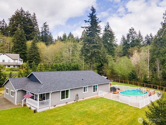 4 Dakota Ln, Elma, WA 98541 - rear view of property with crawl space, a shingled roof, fence, a yard, and a fenced in pool