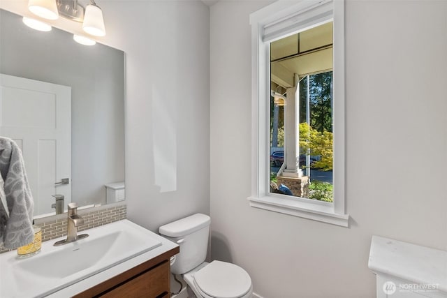 bathroom featuring toilet, tasteful backsplash, and vanity