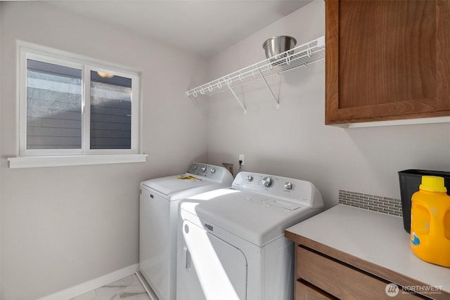 laundry area featuring washing machine and clothes dryer, baseboards, marble finish floor, and cabinet space