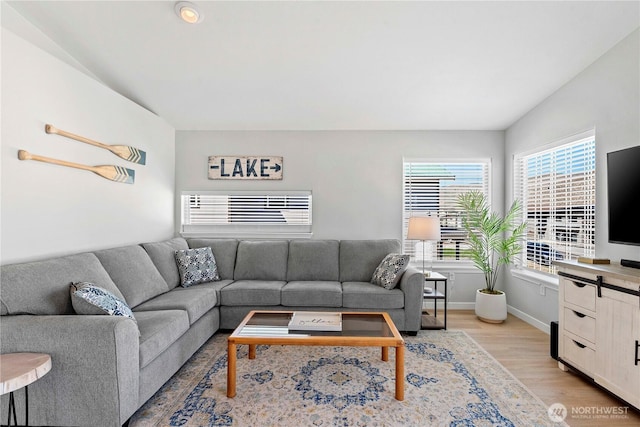 living room with light wood-type flooring and baseboards