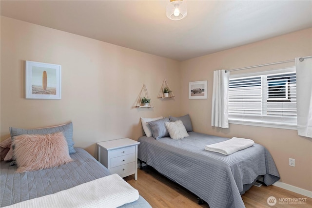 bedroom with baseboards and light wood-style flooring