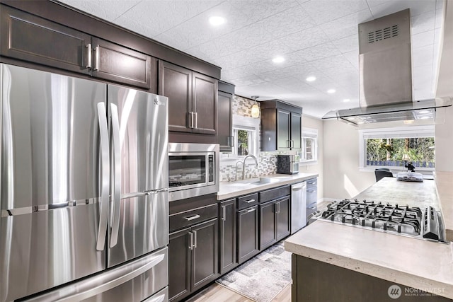 2376 Forest View Dr, Bellingham, WA 98229 - kitchen featuring appliances with stainless steel finishes, wall chimney range hood, light countertops, dark brown cabinetry, and recessed lighting