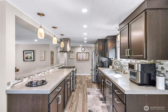 2376 Forest View Dr, Bellingham, WA 98229 - kitchen with island exhaust hood, stainless steel appliances, dark brown cabinetry, recessed lighting, and decorative backsplash