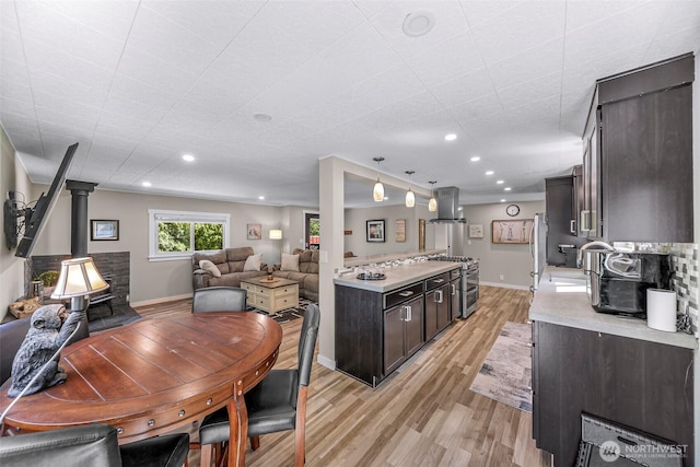 2376 Forest View Dr, Bellingham, WA 98229 - kitchen featuring a wood stove, light countertops, island exhaust hood, light wood-type flooring, and open floor plan