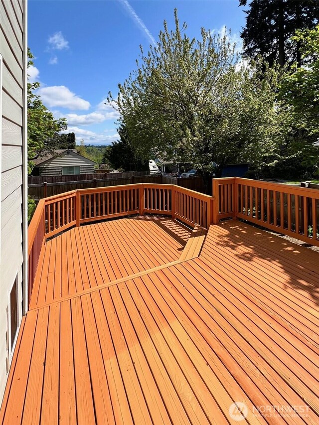 wooden terrace with a fenced backyard