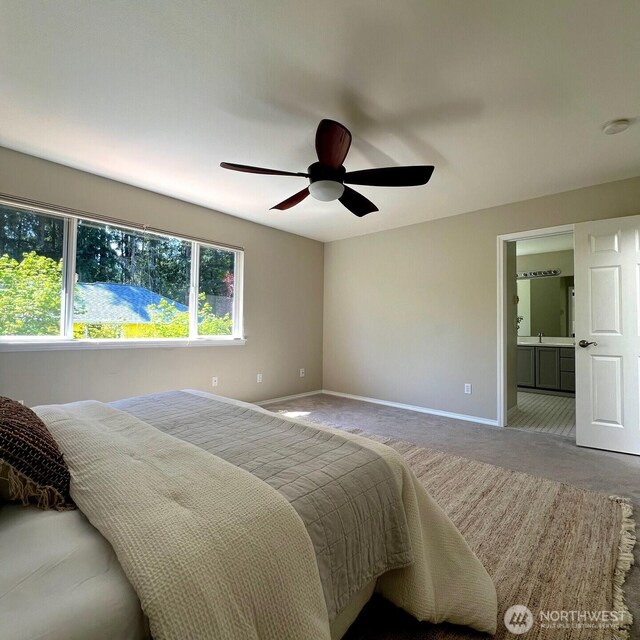 bedroom with baseboards, carpet flooring, a ceiling fan, and ensuite bath